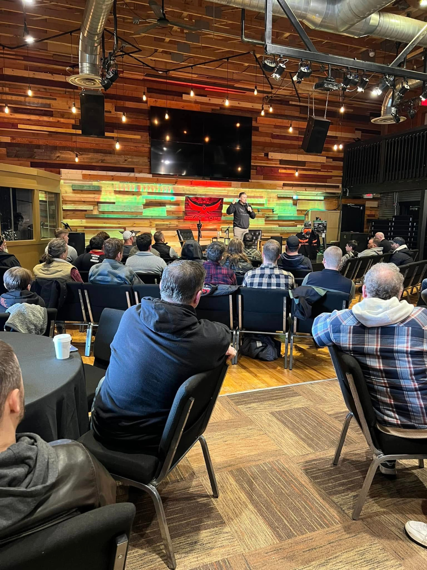 Men gathered at a Grace Ops night beneath the Grace Ops banner
