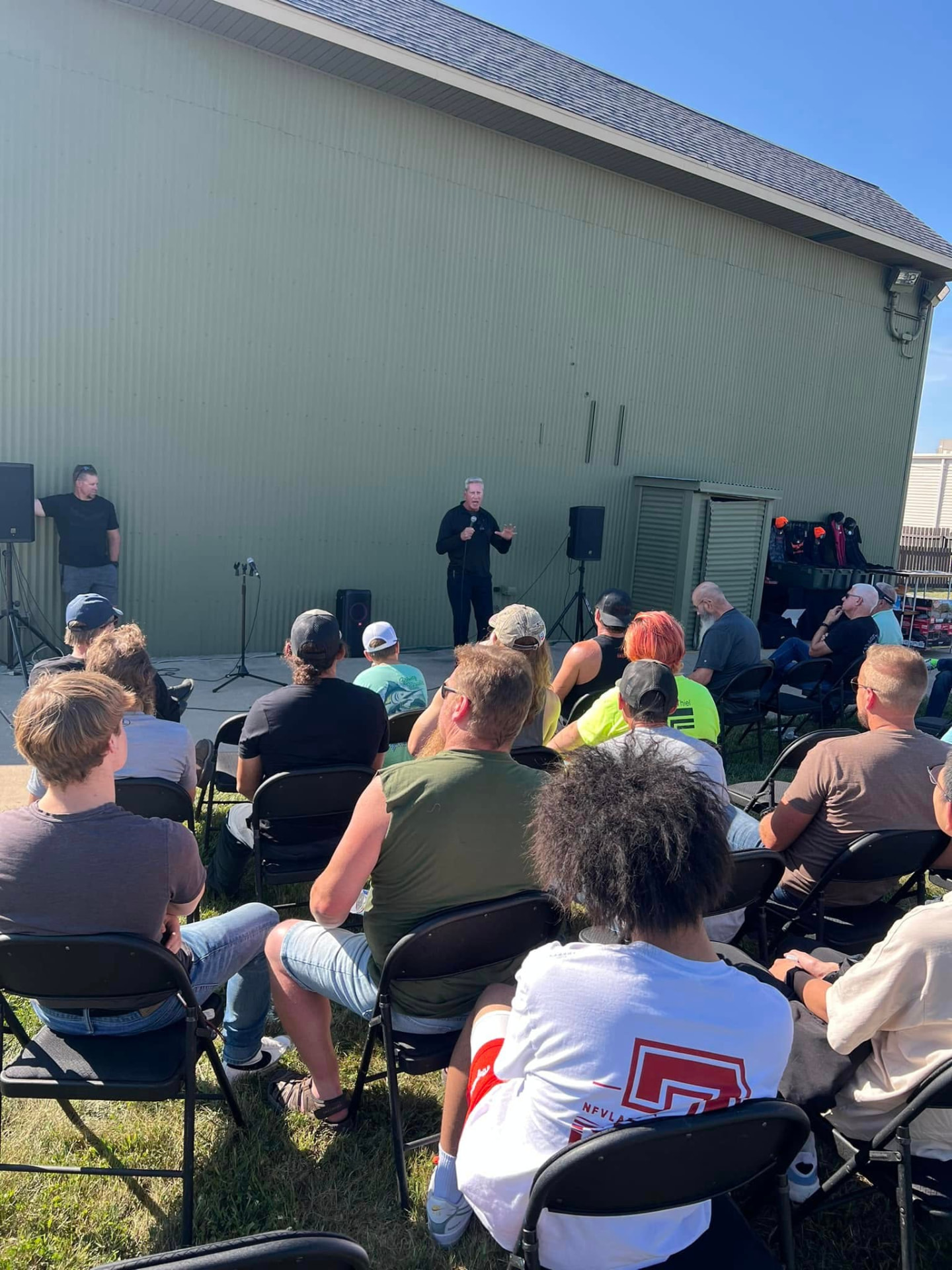 Men seated outdoors listening to a Grace Ops talk